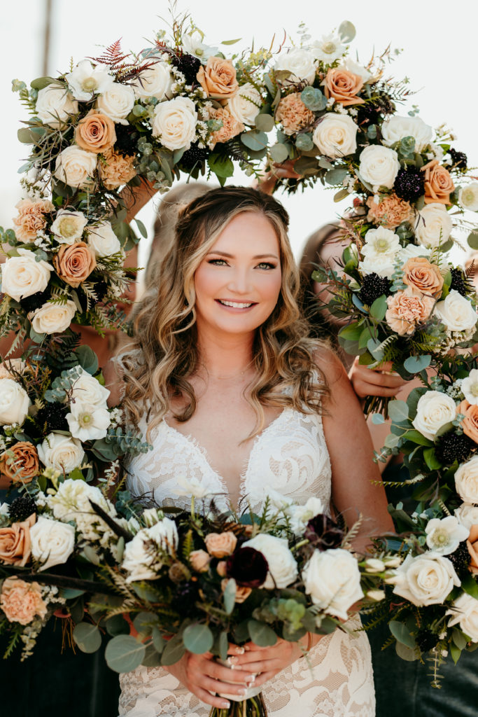 joyous bride framed by her wedding flowers